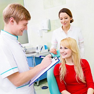 Dentist talking to female patient about services