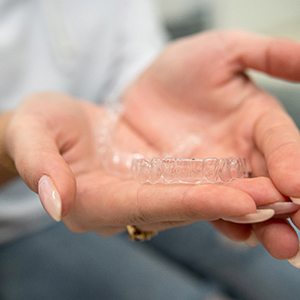 Closeup of patient holding clear aligner
