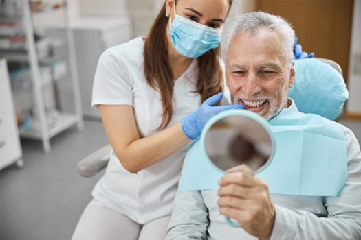 a patient checking his smile with a mirror