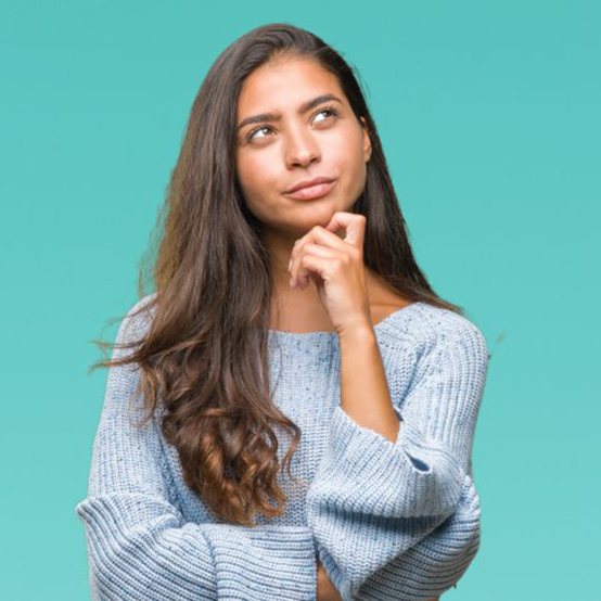 Woman pressing a knuckle to her chin in a questioning pose