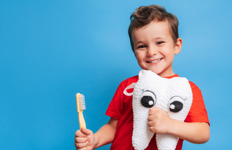 Little boy with toothbrush and crocheted tooth plushie