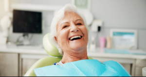 Senior woman sitting back in dental chair and smiling